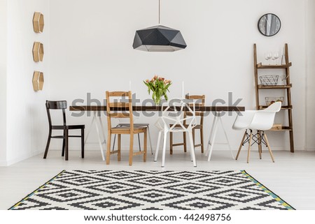 Shot of a table and different chairs in a dining room
