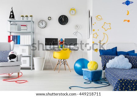 Bright child room with bed, chairs, desk and interesting stickers on the wall