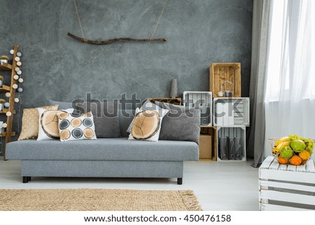 New design grey interior with sofa, DIY furniture and decorative stucco italiano wall