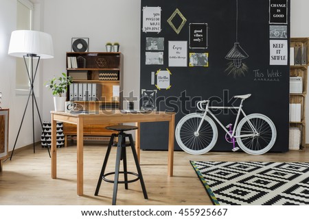 Shot of a stylish studio interior with a minimalistic workspace and a big blackboard