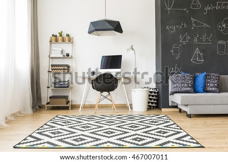 Shot of an elegant student room with a big blackboard and minimalist desk for work