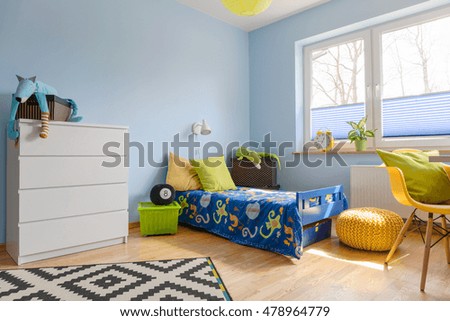 Pastel child room with a chest of drawer, bed, pouf and big window