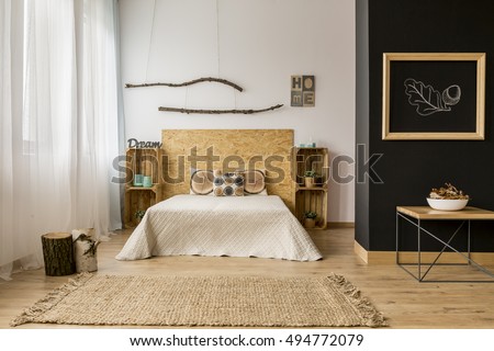 Black and white bedroom with wooden DIY furniture and creative home decor