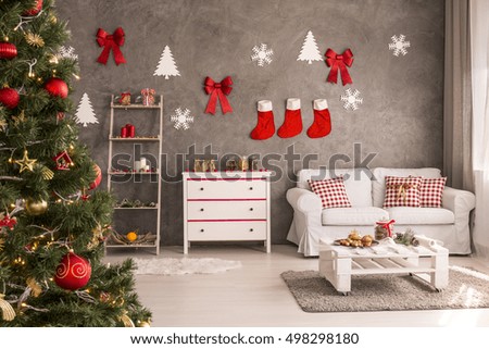 Modern and spacious living room with decorated Christmas tree and DIY wall decor