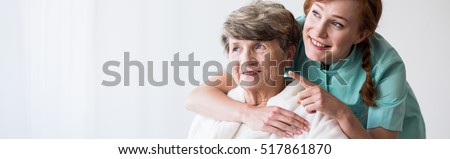 Young pretty caregiver and older happy woman