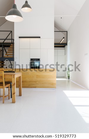 Modern minimalist kitchen with wooden furnitures, white walls and high ceiling
