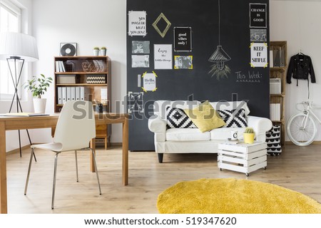 Creative living room with chalkboard wall, wooden desk and vintage furniture
