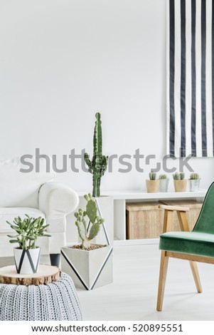 White room with green chair, pouf and sofa
