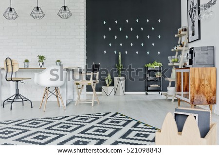 White room with decorative chalkboard wall, table and pattern carpet