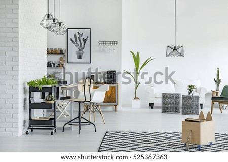 White apartment with pattern carpet, brick wall, table and sofa