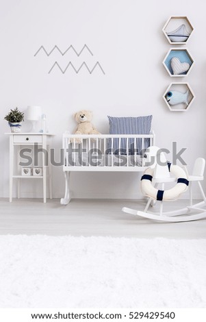 White minimalist room for baby with rocking horse and cradle