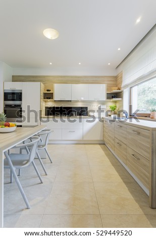 Beige and white kitchen decor, with tiled floor, white cabinets and wooden chest of drawers