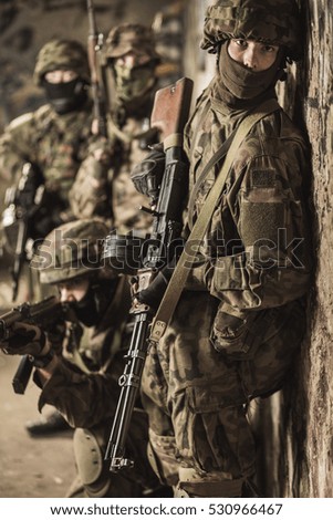 Special forces soldiers with guns taking part in military maneuver during war