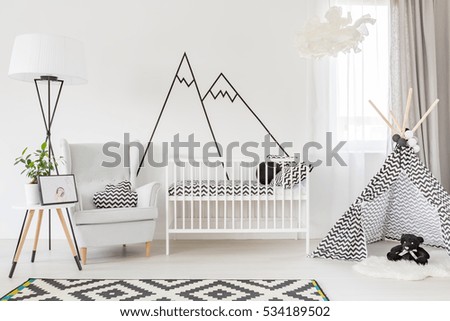 Light functional baby room with cot, play tent and armchair