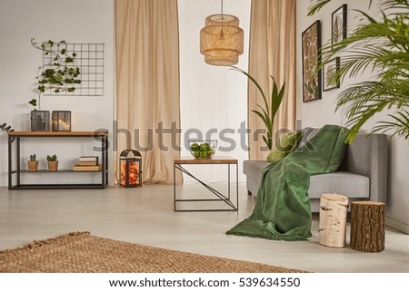 Living room with chandelier, sofa and beige window curtains