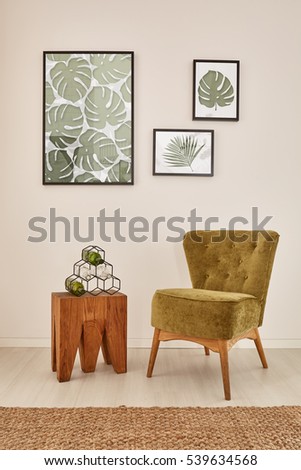 White room with monstera leaf wall decor and green armchair