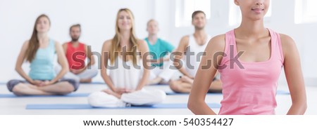 Relaxed people meditating with their eyes closed in wellness centre