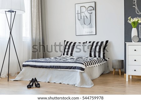 Stylish woman\'s bedroom with comfortable bed and high heels on the floor