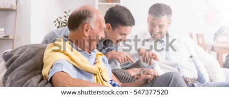 Son, father and grandfather looking at old photos together