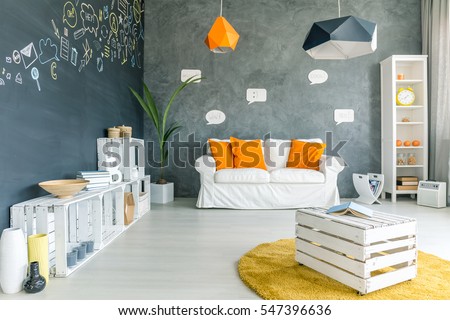 Room with chalkboard wall, sofa and white crate furniture