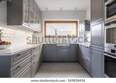 Light, spacious kitchen with window and white brick tiles