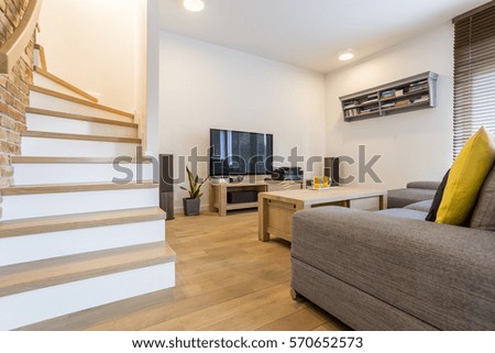 Living room with stairs, sofa and television