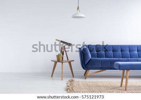 Bright apartment with blue sofa, bench, rug, lamp and table