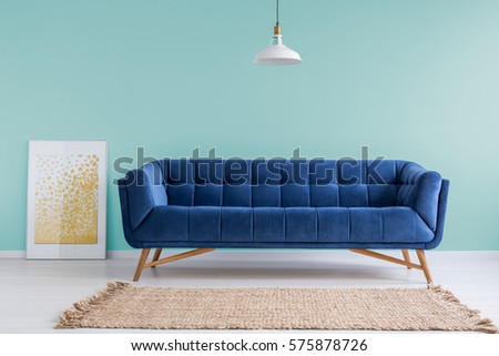 Mint living room with blue sofa, rug and lamp