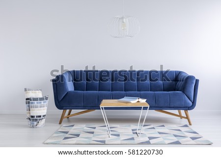 White room with pattern carpet, blue sofa and table