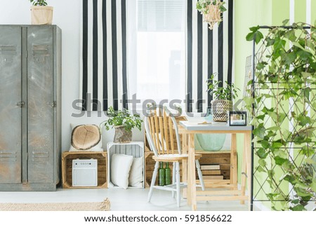 Room with striped window curtain, metal wardrobe, desk and chair