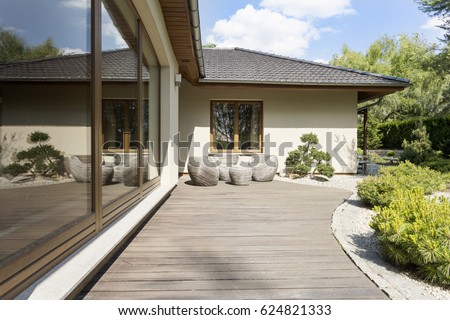 Wooden deck of a terrace by a white suburban villa