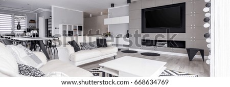 Elegant, black and white relax zone with home cinema system