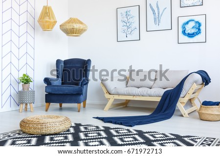 Stylish blue and white living room interior with armchair and sofa
