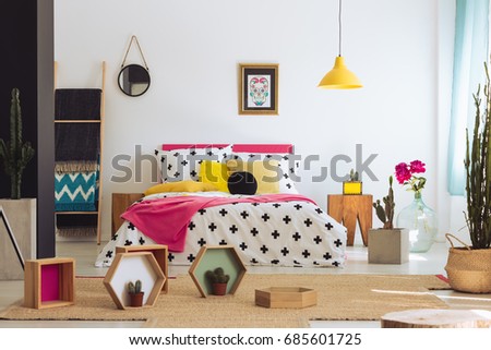 Geometric bedroom with colorful bed, cactus and cross duvet cover