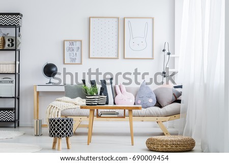 Pastel girly room with simple sofa with decorative pillows