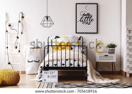 Retro yellow clock on white bedside cabinet in creative kids bedroom with poster on wall