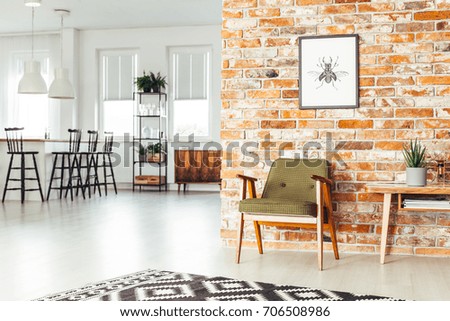 White lamps above countertop with bar stools in dining room with rustic furniture and poster on brick wall