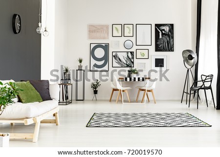 Bright spacious dining room with posters on the wall and white sofa