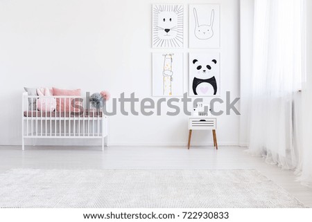 Panda drawing on wall above white cabinet in girl\'s bedroom with pink pillows on bed