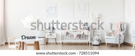 Three simple posters hanging on white wall in cozy room for baby