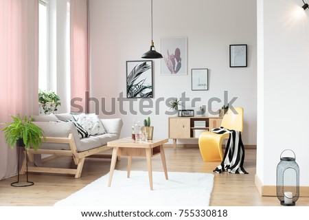 Pink pastel curtains in living room and yellow designer chair