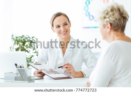 Smiling nutritionist showing a healthy diet plan to female patient with diabetes