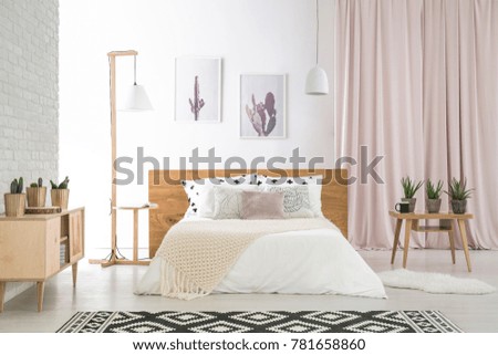 Big bed with white bedding in natural, wooden bedroom