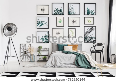 Spacious botanic themed bedroom interior decorated with posters of herbs and bugs