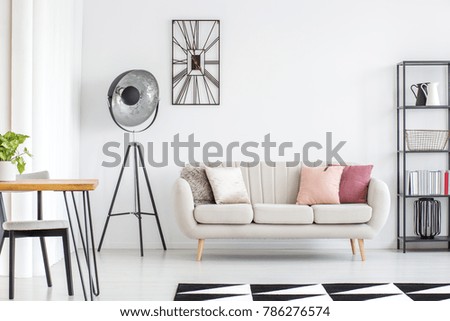 All white room with grey sofa, metal furniture and black and white carpet