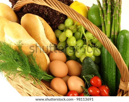 Basket with vegetables, fruits, bread and eggs