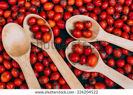 Hawthorn on wooden rustic table background. Rose hips haw fruit of the dog rose