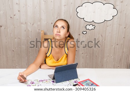 The pretty young student girl studying and thinks about something, with comic cloud