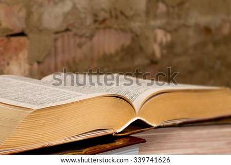 stack thick books on the table against a brick wall