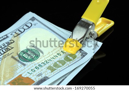 Money is tight concept US one hundred dollar bills squeezed tight in a tool clamp
